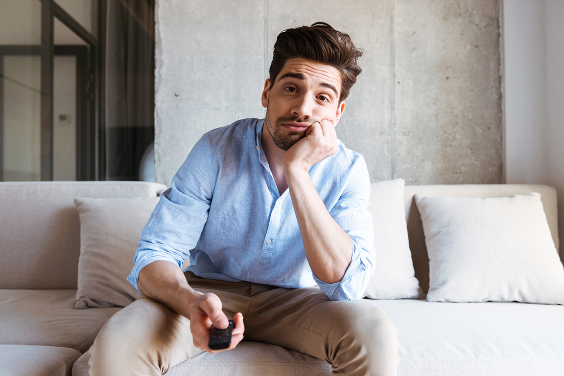 Man bored sitting on couch